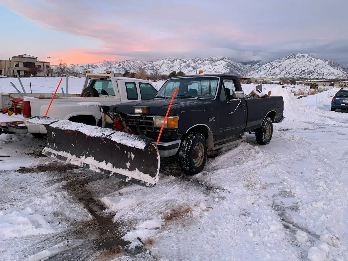 Pickup truck with a snow plow blade parked in fresh snow